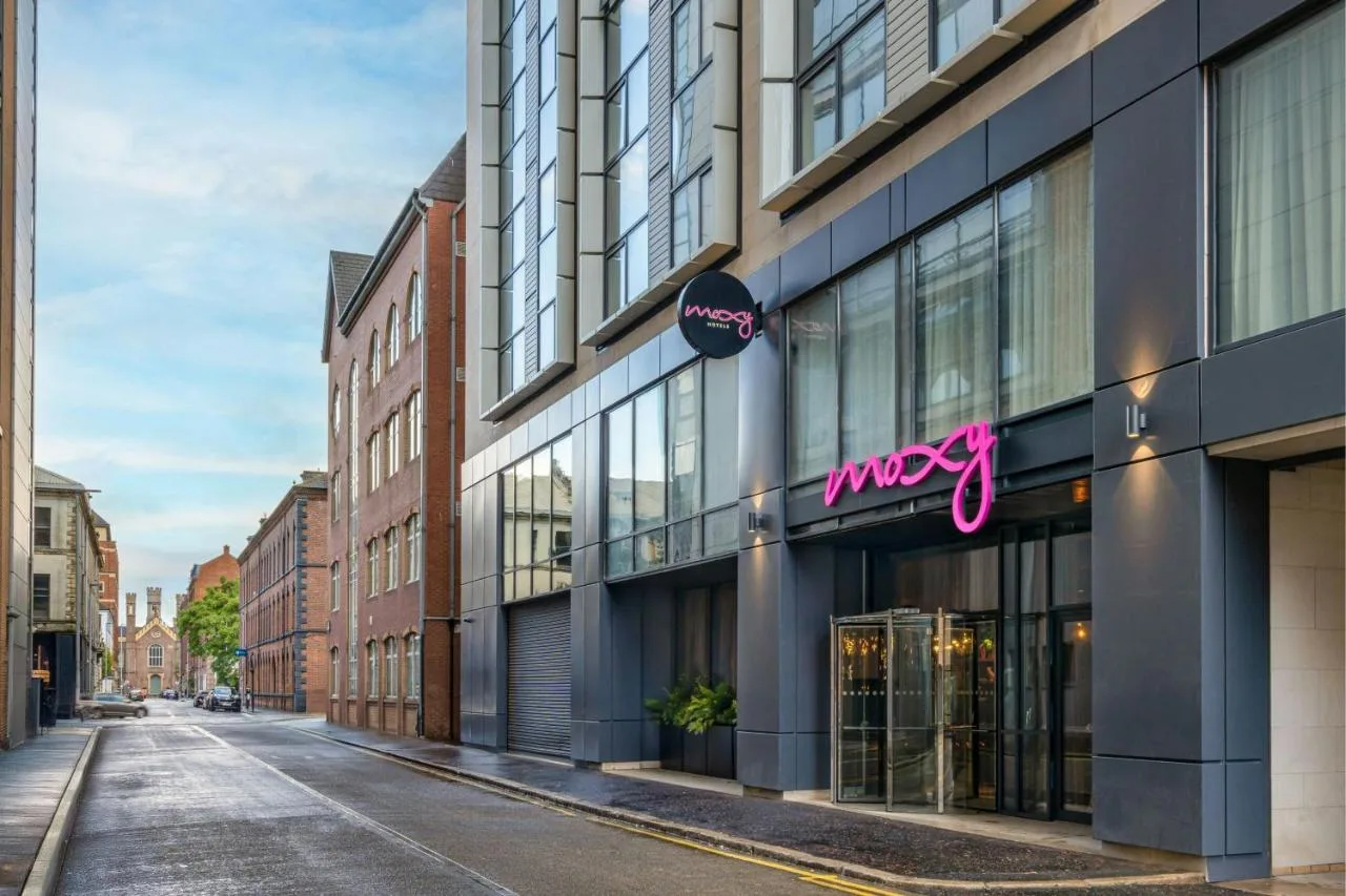 a building on a city street with a store at Moxy Belfast City in Belfast