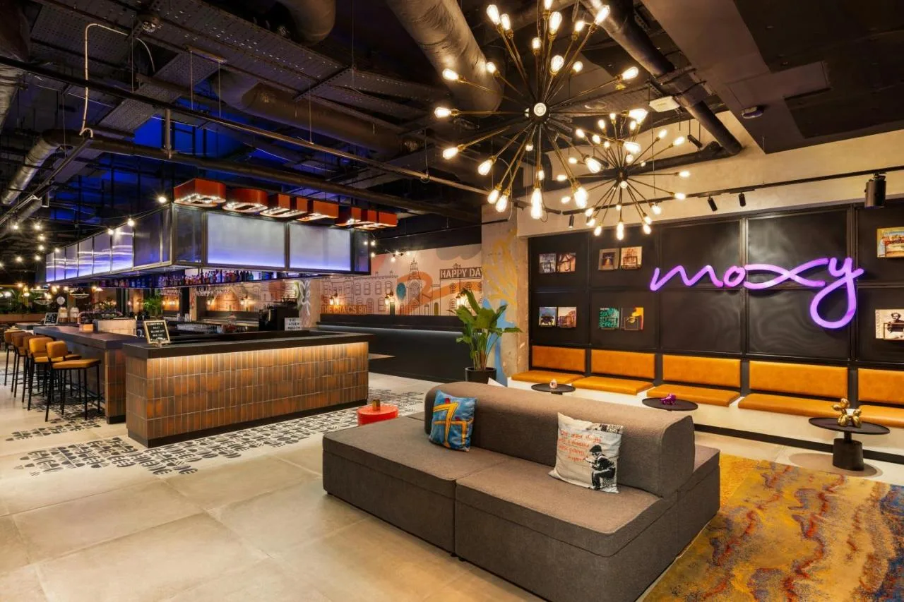 a lobby with a couch and a bar at Moxy Belfast City in Belfast