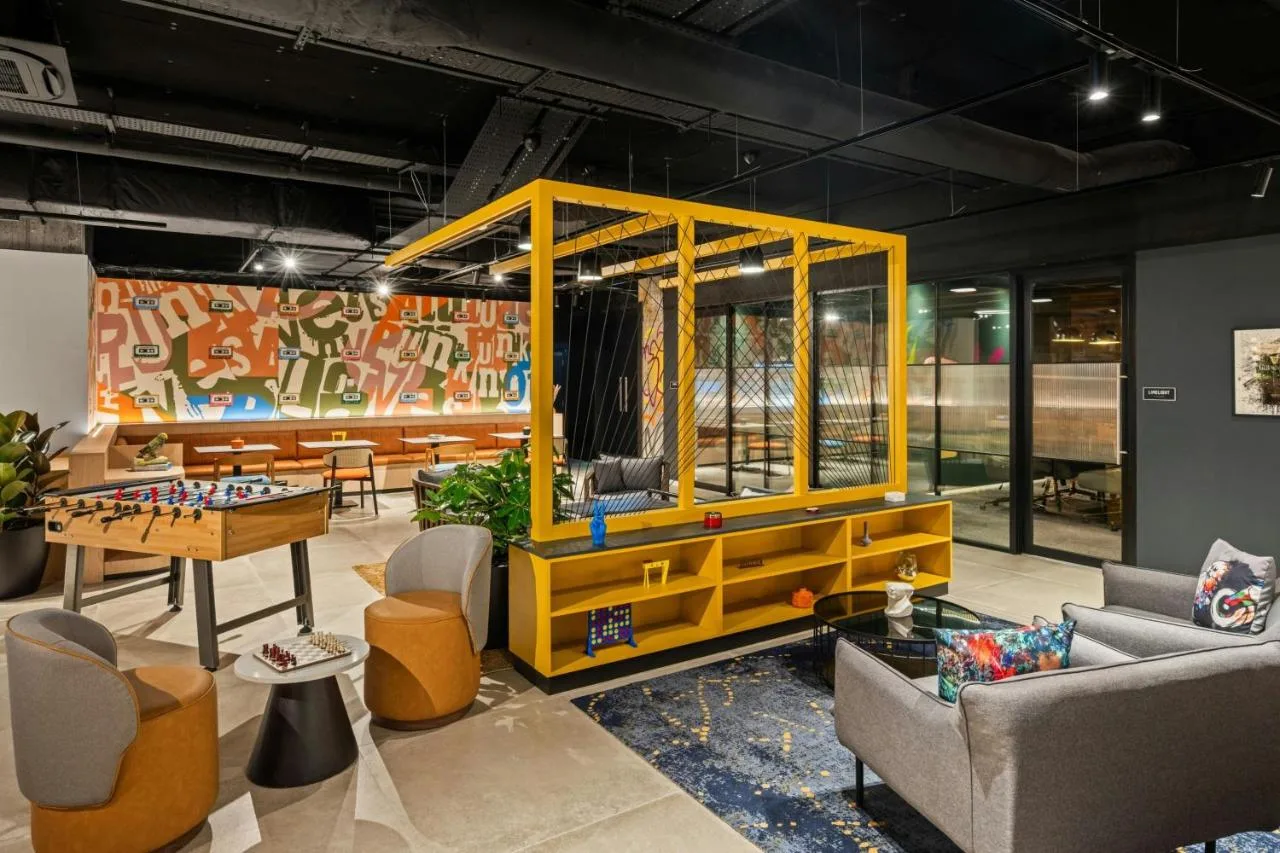 a living room with a table and a game room at Moxy Belfast City in Belfast
